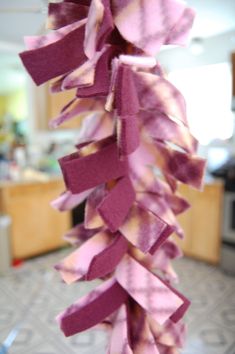 a bunch of purple ribbons are hanging from a kitchen rack in front of a stove