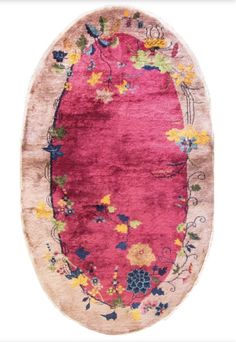 an oval rug with pink and yellow flowers on the bottom, in front of a white background