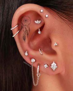 a woman's ear with several piercings on it