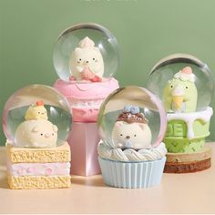 three snow globes sitting on top of a table filled with cakes and cupcakes