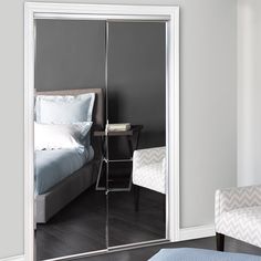 an image of a bedroom with mirrored doors in the door way and a bed on the other side