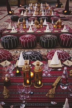 an elaborately decorated table with candles and place settings on top of red carpeted area