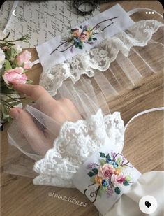 two white garters with flowers on them sitting on top of a wooden table