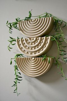 three ceramic bowls with green stems on the top and one is shaped like spirals