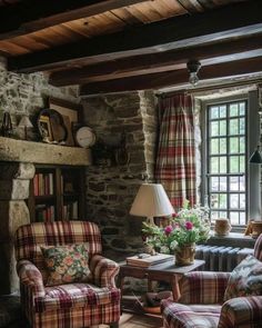 a living room filled with furniture and a fire place in front of a stone wall