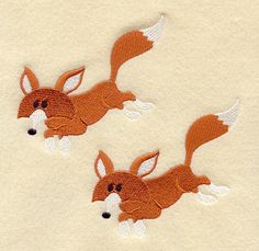 two embroidered fox patches on a white shirt, one with an orange tail and the other has a black nose