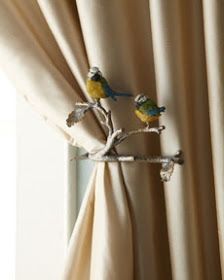 two birds are perched on the branch of a curtain