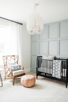 a baby's room with a crib, rocking chair and chandelier