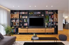 a living room filled with furniture and a flat screen tv on top of a wooden entertainment center