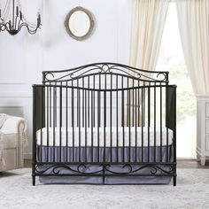 a black crib in a white room with curtains