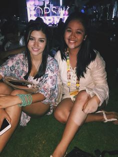 two young women sitting on the grass together