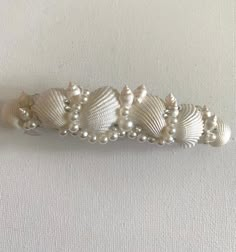 several white seashells and pearls on a white background