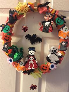 a wreath made out of halloween items hanging on a door