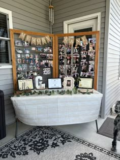 a dog standing in front of a table with pictures on it and decorations hanging from the wall