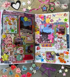 an open scrapbook with lots of stickers on the pages and some paper hearts