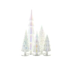 three small plastic trees are standing next to each other on a white surface, one is multicolored