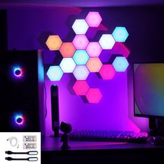 a desktop computer sitting on top of a desk next to a keyboard and monitor in front of a colorful hexagonal wall