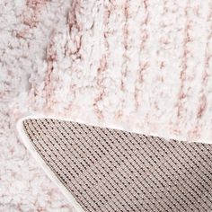 a cat laying on top of a white rug next to a pink and gray wall