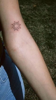 a person with a small sun tattoo on their arm