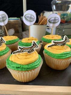 several cupcakes with green frosting and brown icing are on a table