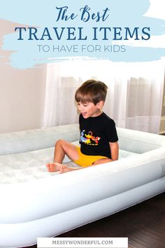 a young boy sitting on an inflatable bed with the text, the best travel items to have for kids