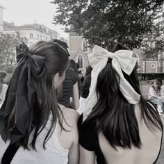 two girls with bows on their heads are looking at something