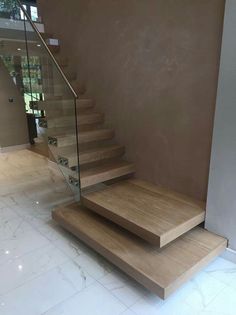 a set of wooden stairs with glass railing