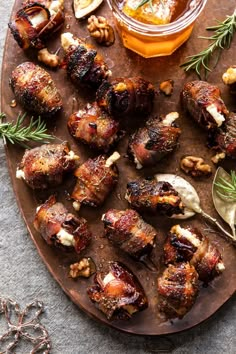 meat and vegetables on a wooden platter next to a jar of honey