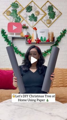 a woman is holding two large tubes in front of her face and the words let's diy christmas tree at home using paper