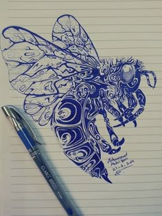 a drawing of a bee on lined paper next to a ballpoint pen and ink