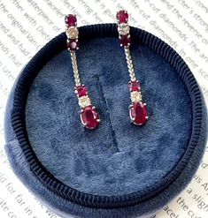 Show off your elegant style with these stunning Vintage 14K White Gold Ruby & Diamond Dangling Earrings. The dazzling cranberry colored rubies catch the light beautifully, while the sparkling diamonds provide the perfect contrast and added elegance. These handcrafted earrings feature a vintage design with the rubies and diamonds dangling delicately. With their timeless beauty and sophisticated look, these ruby and diamond earrings are sure to turn heads and stand out at any special occasion. Make these gorgeous earrings your go-to accessory for a glamorous touch to any outfit. Treat yourself or someone special to these one-of-a-kind vintage earrings today! Metal: 14K White Gold Weight: 3.6 grams (without back) Ruby: Approximately 0.75 cts Diamond:Approximately 0.35 cts Measurement: 1.4 inc Diamond Dangling Earrings, Ruby And Diamond Earrings, Rubies And Diamonds, Estate Diamond Jewelry, Cranberry Color, Hanging Earrings, Dangling Earrings, Ruby Diamond, Handcrafted Earrings