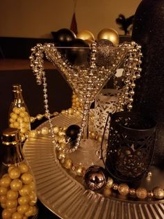 a table topped with lots of gold and black decorations on top of a glass plate