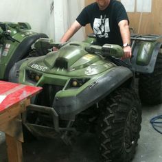 a man working on an atv in a garage