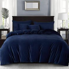 a bed with blue sheets and pillows in a room