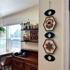 three hanging decorations on the wall above a desk