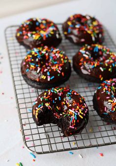 chocolate donuts with sprinkles on a cooling rack