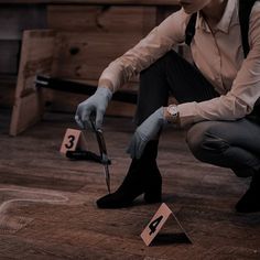 a man kneeling down on the floor holding scissors