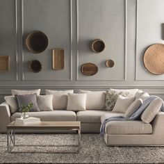 a living room filled with lots of furniture next to a wall covered in plates and bowls