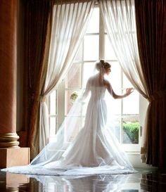 a bride standing in front of a window