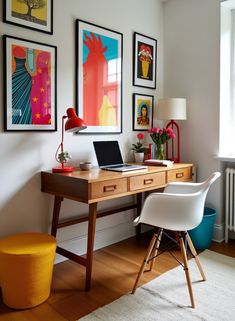 a desk with a laptop computer on top of it next to pictures and a yellow stool