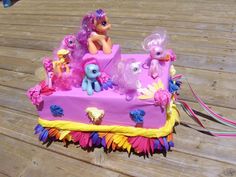 there is a pink cake with many little ponys on it