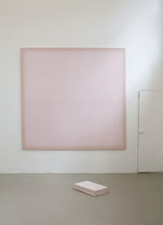 an empty room with a pink painting on the wall