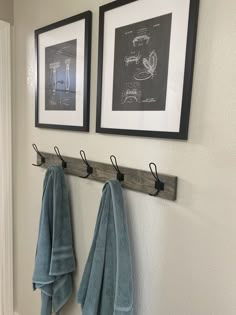 two framed pictures hang on the wall above towels