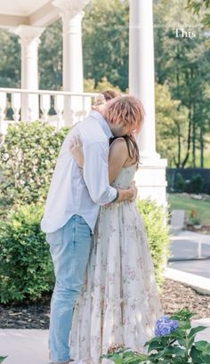 a man and woman embracing each other in front of a gazebo with flowers on it