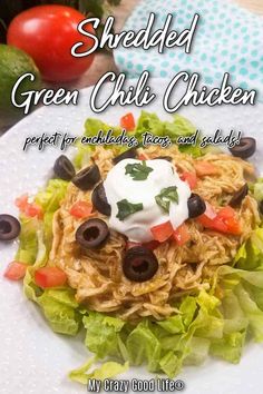 shredded green chili chicken on a plate with lettuce, olives and tomatoes