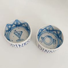 two blue and white bowls sitting next to each other