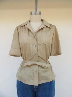 80s linen look khaki button front safari shirt, or perhaps short sleeve tie waist blazer. No labels present. Best guess for fabric would be poly with a linen texture, look, and feel. Two chest pockets. Some elastic at the waist. Nice quality. Love this silhouette Label size not present, fits like S Please compare measurements to a similar garment that fits you well Measured flat  15-1/2" shoulder to shoulder 19" pit to pit 22-1/2" top to bottom  10-1/2" sleeves Good vintage condition with minimal signs of use and age. Safari Shirt Women, Waist Blazer, Safari Shirt, Safari Style, Linen Texture, Womens Blouses, Shirt Short Sleeve, Shirt Women, Sewing Inspiration