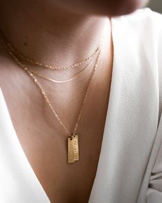 "This vertical bar necklace is a classic, easy to gift piece. From the chain to the pendant, this style is made with 14k gold filled or sterling silver pieces, meaning it is built to last. Personalize this necklace with the names, dates, and special words that mean the most to you! 𝗘𝗮𝘀𝘆 𝗧𝗼 𝗦𝘁𝘆𝗹𝗲, 𝗠𝗮𝗱𝗲 𝗧𝗼 𝗟𝗮𝘀𝘁 Our delicate vertical bar necklaces are elegant, perfect for layering, ready to be personalized with your most special sentiments, moments, and memories! Created to las Gold Bar Necklace With Rectangular Pendant For Everyday, Dainty Rectangular Pendant Bar Necklace For Everyday, Personalized Gold Bar Necklace For Everyday, Everyday Personalized Gold Bar Necklace, Gold Engraved Bar Necklace For Everyday, Name Tag Necklace, Necklace With Kids Names, Names Necklace, Bar Necklaces