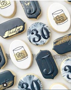 decorated cookies with black and white frosting are arranged in the shape of 30th birthday signs