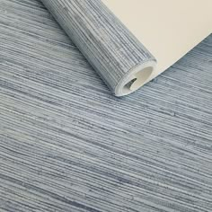 a blue and white striped wallpaper with a roll of paper on top of it